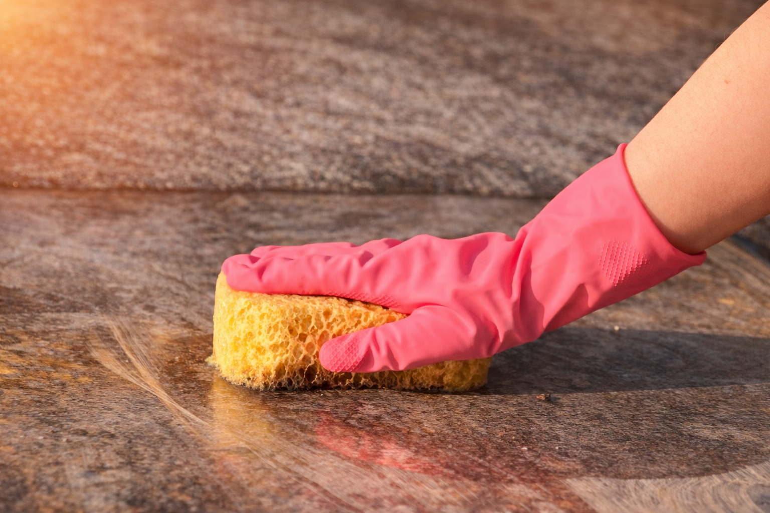 nettoyage sépulture, éponge sur tombe, main gantée qui nettoie une pierre tombale